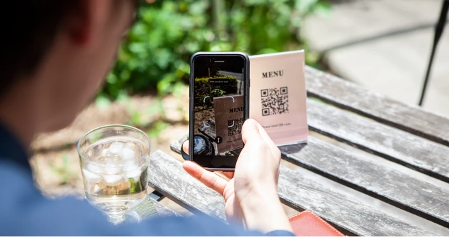 スマートフォンでQRコードを読み取り注文する来店客